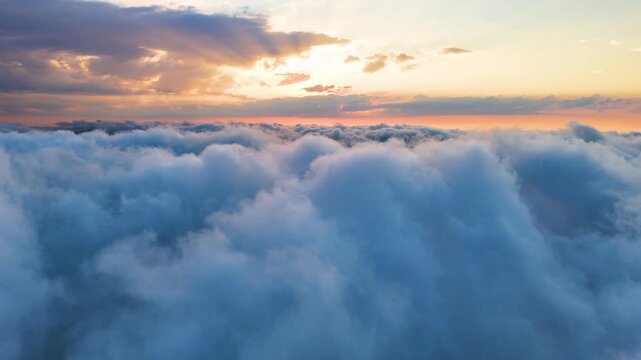 Aerial drone video fluffy sea of clouds during breathtaking sunset Sinop, Black Sea region, Turkey. Stunning cinematic landscape with bright sun shining through colorful dramatic sky and thick cloud