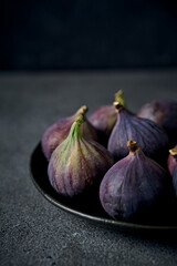 Fresh organic purple figs close up on a ceramic plate