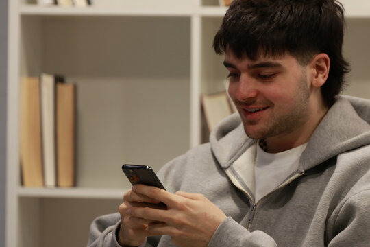 young person or student looking at their mobile phone indoors