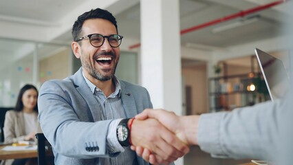 Fototapeta premium Successful business deal celebrating partnership with a firm handshake in modern office