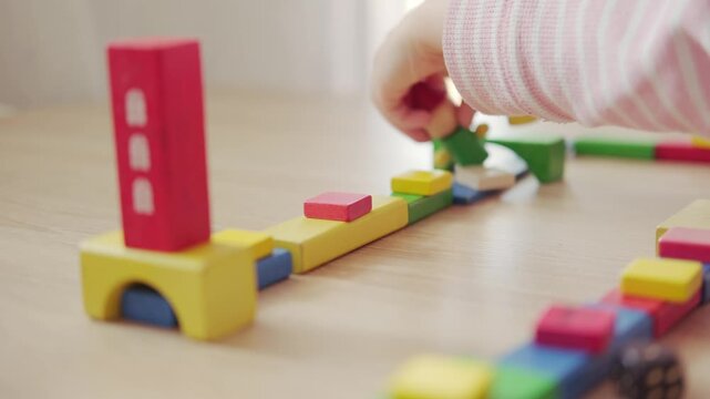 preschool child playing with wooden figures and blocks, development fine motor skills, joy childhood, tactile sensations, early education