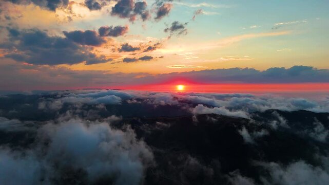 Aerial drone video of mountains and sea of clouds during breathtaking sunset in Sinop, Black Sea region, Turkey. Stunning cinematic landscape with bright sun shining through colorful dramatic sky.