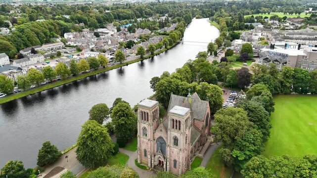 Aerial drone parallax orbit view of Inverness Cathedral and River Ness with city cityscape and bridges in Highland, Scotland