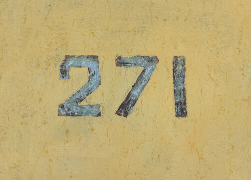 Number 271 on textured background with old yellow paint