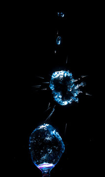 Droplets of water falling and creating splashes in dark background