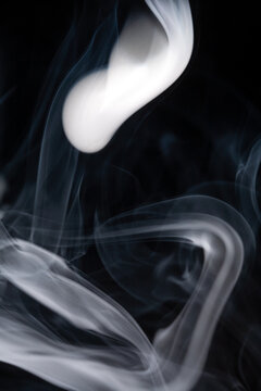 Smoke rises and swirls against a black background creating unique shapes and patterns