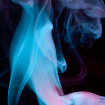 Smoke swirl in shades of blue against a dark background