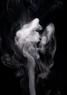 Smoke rises and swirls against a black background creating unique shapes and patterns