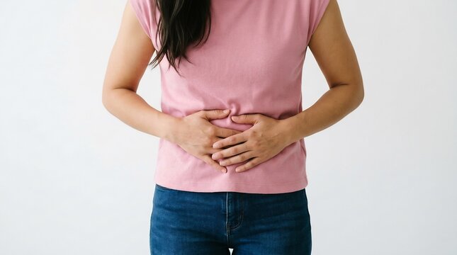Adult woman holding her lower abdomen in pain while wearing a pink
