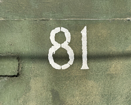 White number 81 on textured background with old paint	
