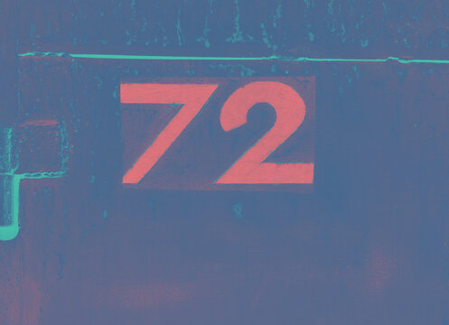 A garage door, number 72 in bold pink lettering on a textured blue metal surface, with a retro color palette, weathered details and ample copy space