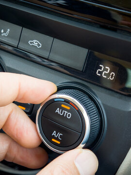 Hand Adjusting Temperature Knob on Modern Car Climate Control Panel