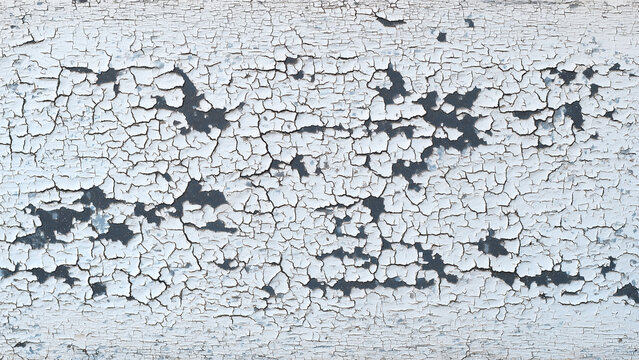 Distressed white enamel paint texture flaking over dark steel full frame