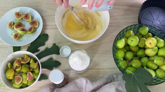 Hands are visible working with various bowls containing ingredients like chopped green items and yellow liquids in a bright kitchen setting, suggesting food preparation activities