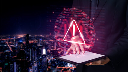 A businessman stands holding a tablet in a vibrant city at night, presenting a holographic alert symbolizing a digital security threat in a modern environment. Gantry © InfiniteFlow