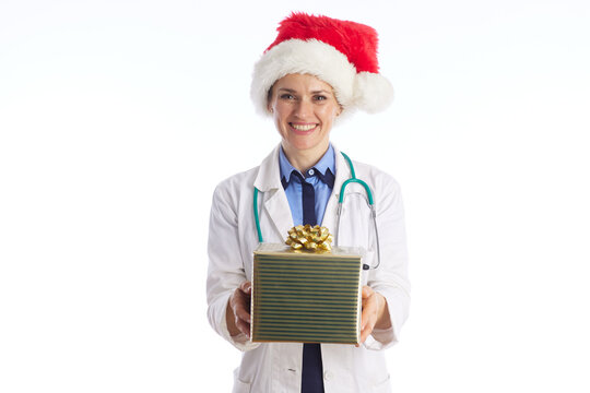 A cheerful medical professional in a lab coat and Santa hat offers a green gift box, symbolizing care, compassion, and holiday spirit in the healthcare industry.