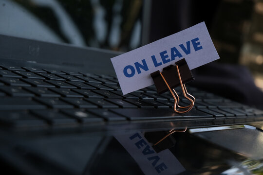 On Leave, annual leave for employees. An "ON LEAVE" sign with a paperclip resting on a keyboard. A break from work. Vacation, family event.
