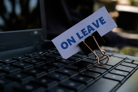 On Leave, annual leave for employees. An "ON LEAVE" sign with a paperclip resting on a keyboard. A break from work. Vacation, family event.

