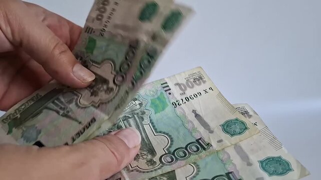 Woman hands counting one thousand russian ruble banknotes close up. russian currency, paper money, cash payment, financial wealth.