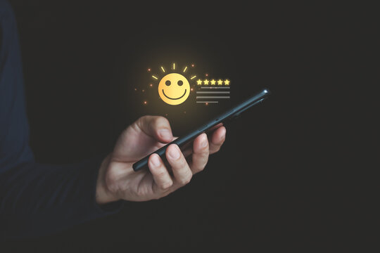 Loyalty rewards and redeem points concept with a smartphone app. A person's hand using a mobile phone with glowing star icon for customer privilege, membership bonus and marketing promotion program.