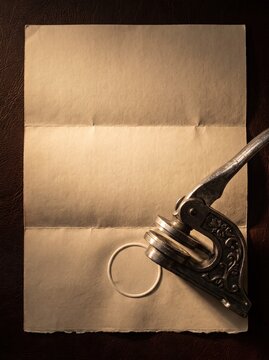 Embossing seal press making blind stamp on aged blank document