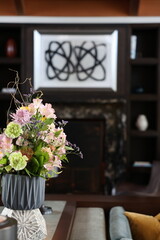 Pink Floral Bouquet on Table with Dark Fireplace Background © Maria Rasin