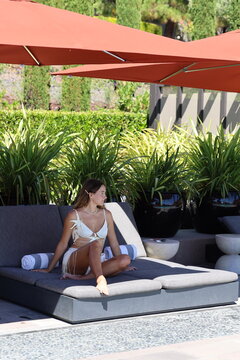 Woman in White Bikini Relaxing on Poolside Lounger, Luxury Resort
