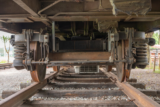 Train bogie undercarriage with wheels, coil springs and brake components resting on railway tracks