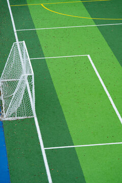 Soccer goal on green artificial turf football pitch with white boundary lines