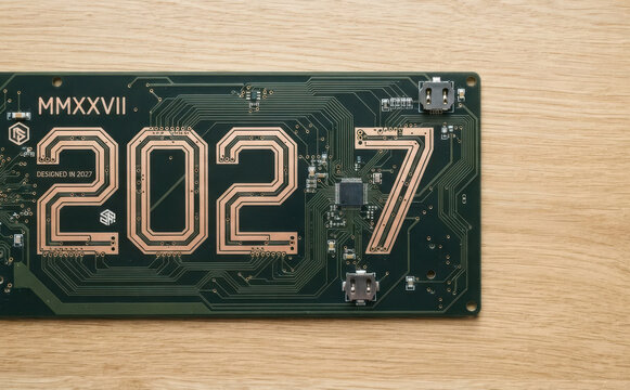 Green circuit board PCB with large 2027 numbers trace tracks futuristic year concept technology design background