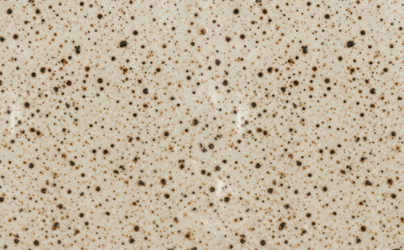 Ceramic glaze texture with speckled brown spots on beige background for pottery and ceramic design concepts