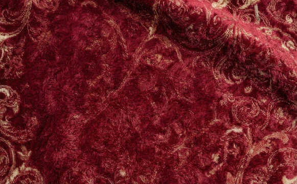 Burgundy red velvet fabric with ornate damask pattern texture for luxury interior design upholstery and elegant fashion apparel background