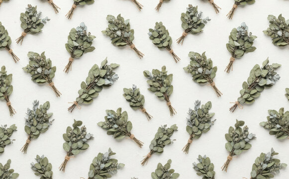 Seamless pattern of dried eucalyptus bundles arranged neatly on a white background, ideal for organic wellness, botanical design, spa branding, and natural cosmetic packaging backgrounds