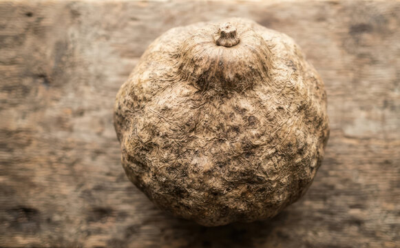 Raw Pueraria Mirifica tuber root on a rustic wooden background representing traditional herbal medicine and natural cosmetics ingredient