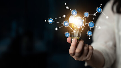 A hand holds a glowing light bulb amidst a digital network. The image symbolizes innovation and creativity in technology, representing bright ideas in a modern context. Tessel © InfiniteFlow