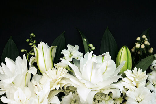 White delicate lily flowers composition, condolence flower background card, funeral concept image, selective focus, shallow DOF