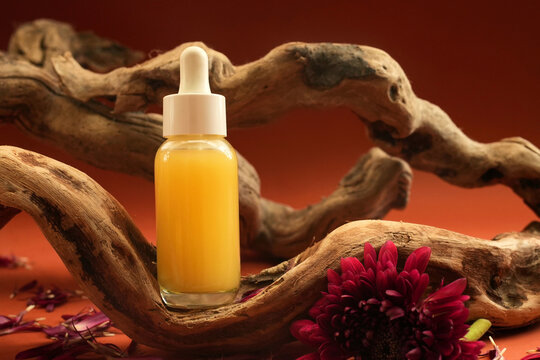 Cosmetic serum bottle on delicate flowers background, natural  scincare cosmetics, beauty and facial care concept image, selective focus, shallow DOF