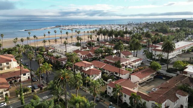 Aerial drone shot towards Cabrillo Blvd. and Santa Barbara Harbor over classic Spanish architecture in Santa Barbara, California, near State Street. Shot on a beautiful afternoon, January 2024.