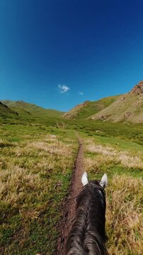 First person POV view of riding a horse towards Song Kul lake in Kyrgyzstan