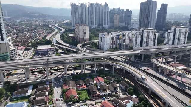 Aerial view with a smooth panning shot of multi-level highway flyovers and urban traffic in Kuala Lumpur Malaysia
