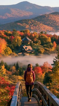 a serene autumn landscape. A person stands on a wooden bridge, facing away from the viewer, wearing a purple jacket and carrying a backpack.