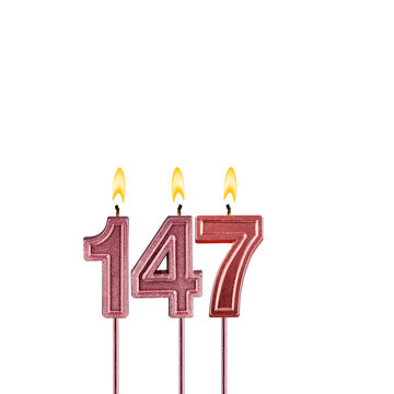 Candle number 147 - Lit birthday candle on white background