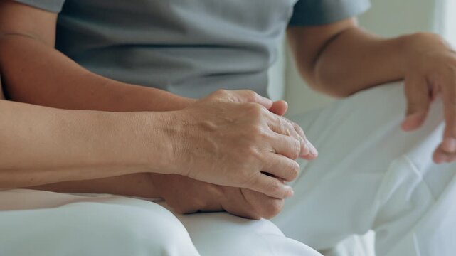 Close up view of caring elderly grandma wife holding hand supporting senior grandpa husband give empathy care love, old married grandparents couple together