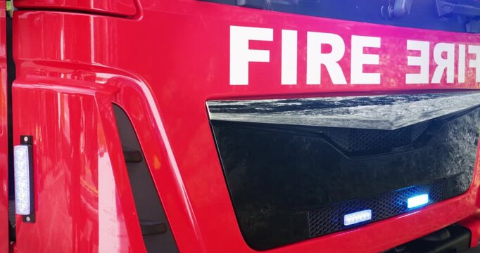 Fire truck emergency service vehicle with flashing lights. Red fire engine with ladders, firefighting apparatus and water to save lives, extinguish fires and assist vehicle collision.