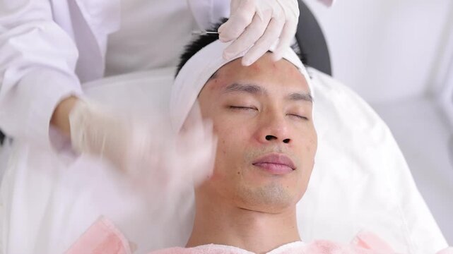 Male patient receiving professional acne and blackhead extraction treatment from a dermatologist in a beauty clinic. Skincare procedure for men.
