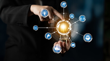 A business professional holds a light bulb surrounded by digital icons representing ideas and innovation, illustrating the importance of technology and creativity in corporate solutions. Crux © InfiniteFlow