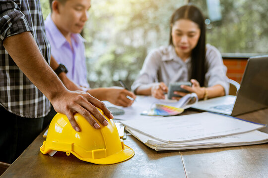Contractor and engineer with blueprints discuss, choosing materials at a modern construction site, Engineers in mechanical factory reading instructions at construction site office. Selected focus