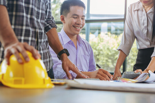 Contractor and engineer with blueprints discuss, choosing materials at a modern construction site, Engineers in mechanical factory reading instructions at construction site office. Selected focus