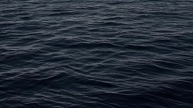 Dark ocean surface with rolling sea wave patterns and rippled water texture creating moody abstract movement for tranquil marine travel, nature design, dramatic backgrounds, and night imagery