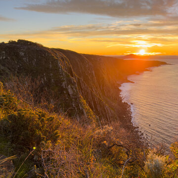 Epic sunrise golden light on the Waitpinga Cliffs at dawn over the ocean and horizon on the Fleurieu Peninsula in South Australia
